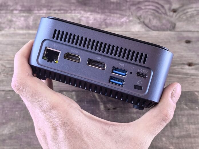 Mini komputer PC z licznymi portami trzymany w dłoni użytkownika Mini komputer PC z licznymi portami trzymany w dłoni użytkownika