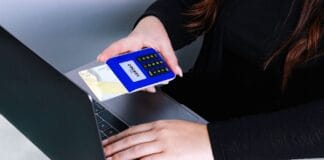 Osoba płacąca kartą przy laptopie jako przykład bezpiecznej transakcji