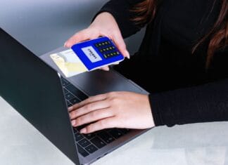 Osoba płacąca kartą przy laptopie jako przykład bezpiecznej transakcji