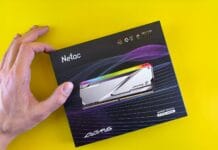 Ile pamięci RAM do gier w 2025 roku: 16 GB, 32 GB czy 64 GB? Dłoń trzymająca opakowanie pamięci RAM Netac DDR5 na żółtym tle