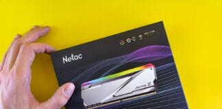 Dłoń trzymająca opakowanie pamięci RAM Netac DDR5 na żółtym tle