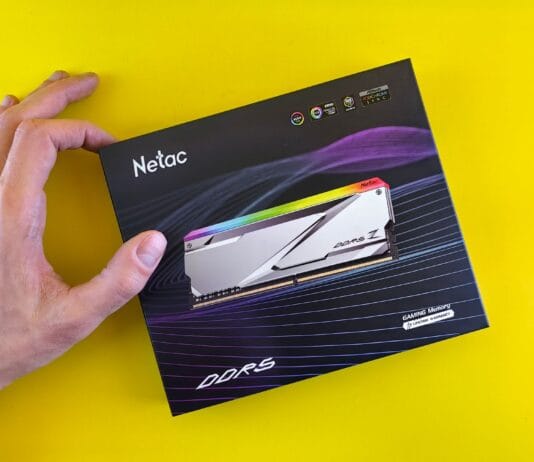 Dłoń trzymająca opakowanie pamięci RAM Netac DDR5 na żółtym tle