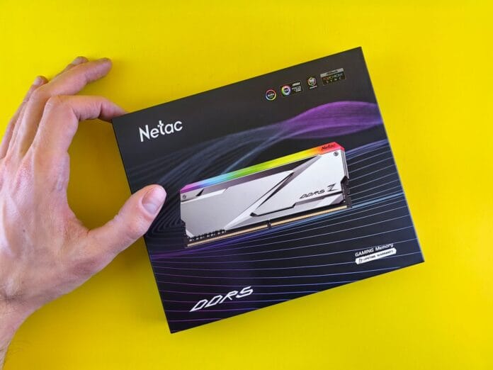 Dłoń trzymająca opakowanie pamięci RAM Netac DDR5 na żółtym tle Dłoń trzymająca opakowanie pamięci RAM Netac DDR5 na żółtym tle